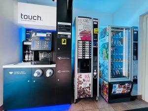 a ticket vending machine next to a drink machine at Luxhostel24 Warsaw in Warsaw