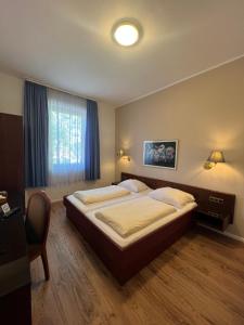 ein Schlafzimmer mit einem großen Bett und einem Fenster in der Unterkunft Central Hotel in Worms