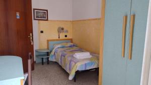 Dormitorio pequeño con cama y mesa en Hotel Rosy, en Bellaria-Igea Marina