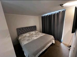 Habitación pequeña con cama y ventana en Tu Mejor Opción., en Santiago