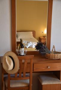 a bedroom with a bed and a table with a mirror at Polizotou Rooms in Skala Sotiros