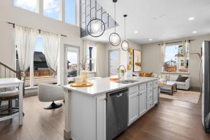 a kitchen with a sink and a living room at Orleans Street - Aurora in Aurora