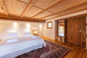 ein Schlafzimmer mit einem weißen Bett und einer Holzdecke in der Unterkunft Gîte Bei der Kirche 4 étoiles in Mundolsheim