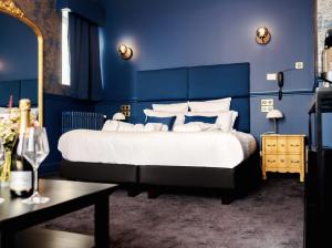 a bedroom with a large bed with blue walls at Hôtel Château Héloïse in Mérélessart
