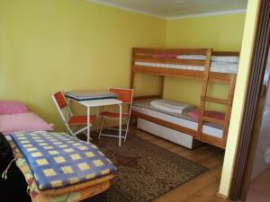 a room with two bunk beds and a table and a desk at Domek Wakacyjny Mały in Stegna