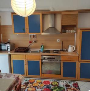 a kitchen with wooden cabinets and a stove and a sink at S.T Family Apartement in Kalabaka