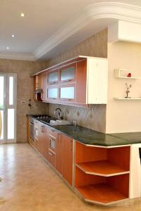 eine Küche mit Holzschränken und einer Arbeitsplatte in der Unterkunft Superbe appartement a La Marsa in La Marsa