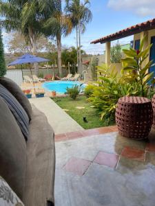 a couch sitting on a patio next to a pool at Pousada Luz do Sol in Carrancas