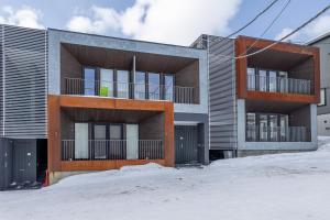 俱知安町Hangetsu Niseko的公寓大楼前面有雪