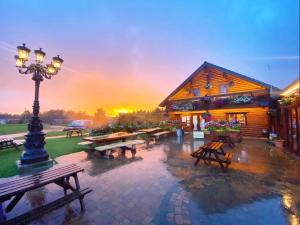 een groep picknicktafels en een gebouw met een straatlicht bij Oakwood Lodge in Morpeth