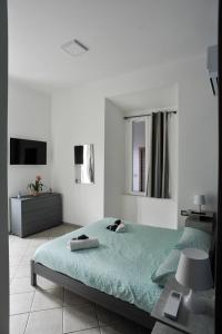 Habitación blanca con cama y TV en In Center apartaments, en Salerno