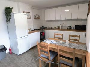 uma cozinha com uma mesa e cadeiras e um frigorífico em Górski Zakątek Brenna em Brenna