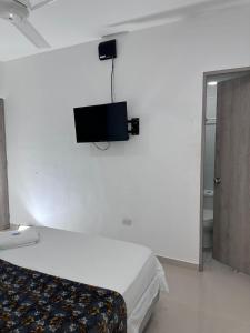 a bedroom with a bed and a tv on the wall at lujoso apartamento central con tres Aires acondicionados y parqueo in Montería +15 photos