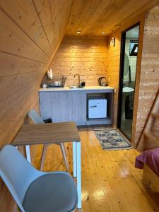 eine Küche in einem Blockhaus mit einem Tisch und Stühlen in der Unterkunft Cottage in Udabno in Udabno