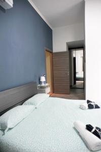 1 dormitorio con 1 cama grande y pared azul en In Center apartaments, en Salerno