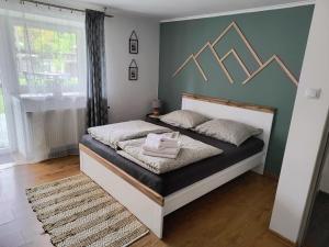 um quarto com uma cama com uma cama em preto e branco em Górski Zakątek Brenna em Brenna