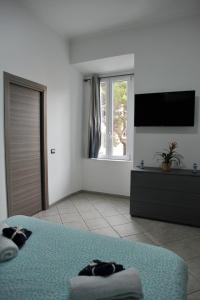 Habitación blanca con cama y TV en In Center apartaments, en Salerno