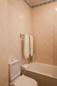 a bathroom with a toilet and a bath tub at Apartamentos Rossio Mar in Albufeira