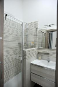 y baño con lavabo, ducha y espejo. en In Center apartaments, en Salerno