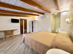 ein Schlafzimmer mit einem großen Bett und einem Schreibtisch in der Unterkunft Dimora degli Ulivi in Caprioli