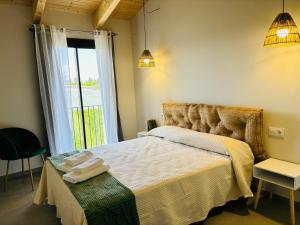 a bedroom with a bed and a large window at Can Mas in Sant Pere Pescador