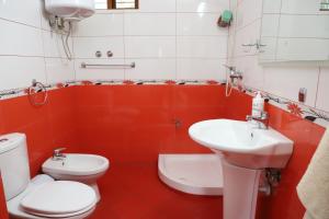 uma casa de banho com um WC branco e um lavatório. em Guest House LION em Berati
