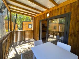 a patio with a white table and chairs on a deck at Camping La Pinède in Calvi