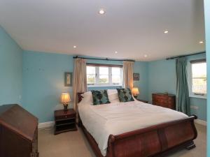 1 dormitorio con 1 cama grande y 2 ventanas en Brook Cottage, en Sturminster Newton