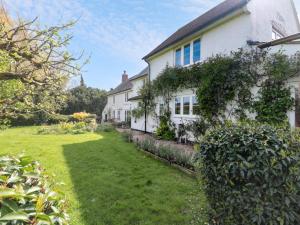 a white house with a yard in front of it at Brook Cottage in Sturminster Newton