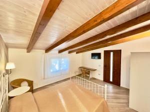 Zimmer mit einem Bett und einer Holzdecke in der Unterkunft Dimora degli Ulivi in Caprioli