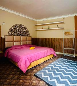 ein Schlafzimmer mit einem großen rosa Bett und einem Teppich in der Unterkunft Hostel 360 Degree Jibhi in Jibhi