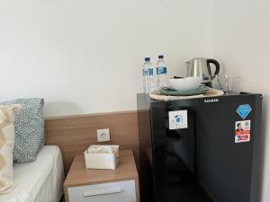 a small refrigerator next to a bed with a table at Homely, Cozy Studio in Seminyak 5 in Seminyak