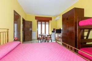 - une chambre avec un grand lit rose et une table dans l'établissement Casa Ai Cappuccini, à Randazzo