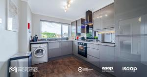 a kitchen with a washer and a washing machine in it at Modern City Centre Apartment. Private Entrance, Garden, Parking, Garage, Quiet Neighbourhood in Peterborough