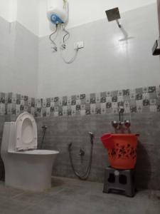 a bathroom with a toilet and a shower and a bucket at OYO Hotel HR International Restaurant 