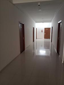 an empty hallway with two doors and a white floor at OYO Hotel HR International Restaurant 