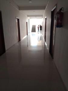 two people walking down a hallway in a building at OYO Hotel HR International Restaurant 