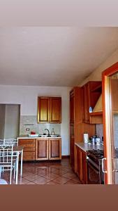 una cocina con armarios de madera y una mesa. en Casa di sotto, en Giratola