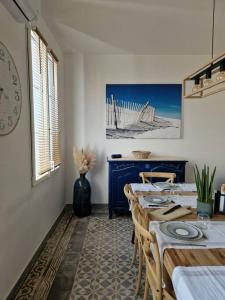 a dining room with a table with chairs and a clock at Leukif - Appartement T4 Duplex 4* avec Rooftop in Leucate +52 photos