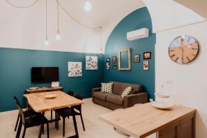 ein Wohnzimmer mit einem Tisch, einem Sofa und einer Uhr in der Unterkunft Casa tutti i frutti in Noci