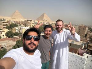 開羅的住宿－LOAY PYRAMIDS VIEW，三个男子在金字塔前摆着一张照片