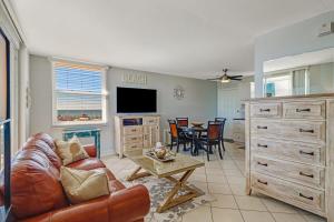 a living room with a couch and a table at Penthouse Views - Steps From the Shore 2001 in Bonita Springs