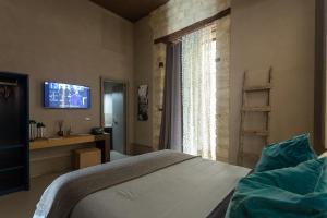 um quarto com uma cama, uma televisão e uma janela em ArtStudio6 Dimora Artistica em Campobasso