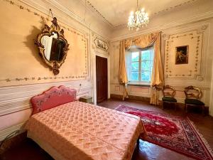 1 dormitorio con cama y espejo en la pared en Villa Arnolfini, en Capannori