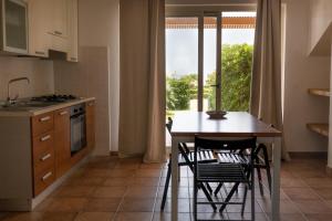 kuchnia ze stołem i krzesłami oraz oknem w obiekcie Agua Residence w mieście Noto