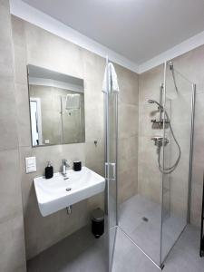 a bathroom with a sink and a shower at Grazora Living Apartments in Graz