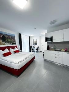 a bedroom with a large bed and a kitchen at Grazora Living Apartments in Graz