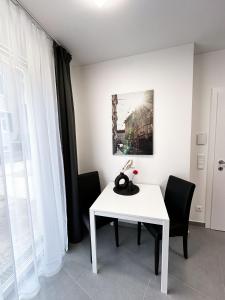 Grazora Living Apartments في غراتس: طاولة بيضاء وكراسي في غرفة