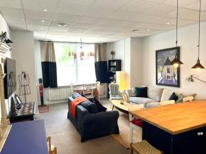 a living room with couches and a table at Hampton Court Grand Snug Sleeps 6 - Walk to Palace and Train in Molesey
