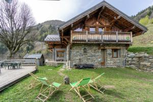 a log cabin with chairs and a deck at Auberge du coin in Saint-Colomban-des-Villards